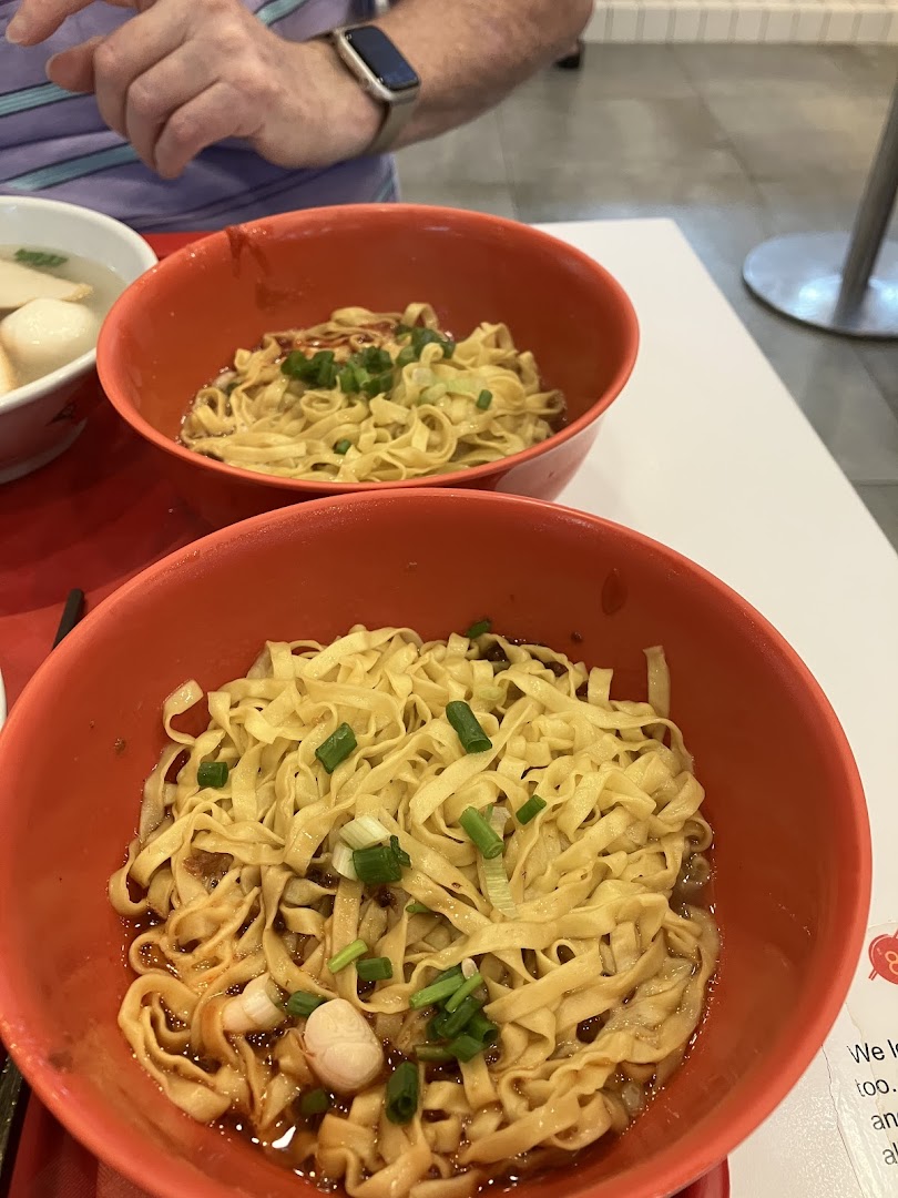 Two vibrant bowls of Teochew-style fishball noodles, garnished with spring onions, ready to be enjoyed.