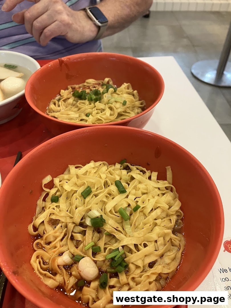 Two vibrant bowls of Teochew-style fishball noodles, garnished with spring onions, ready to be enjoyed.