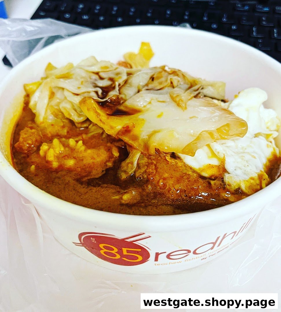 A close-up of a delicious bowl of curry noodles or rice with fishballs and egg from 85 Redhill Teochew Fishball Noodles.