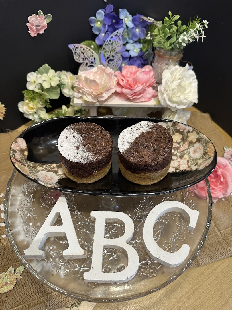 Two chocolate muffins on a decorative plate with 'ABC' letters and floral background.