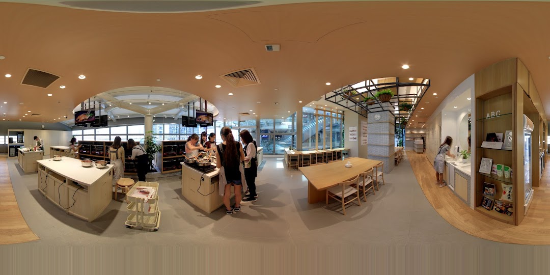 An interior view of ABC Cooking Studio showing a cooking class in progress and a retail display area.