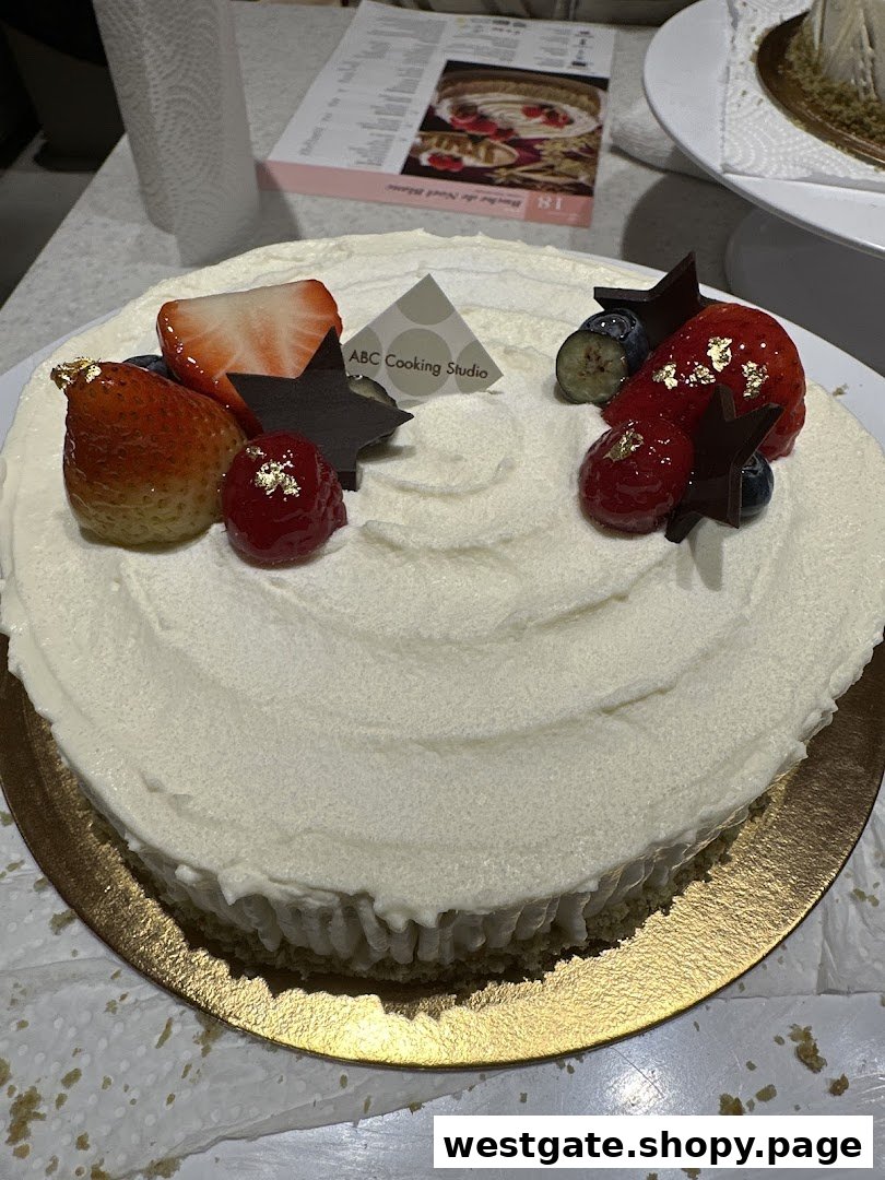 A beautifully decorated cake with fresh berries, chocolate stars, and gold leaf, made at ABC Cooking Studio.