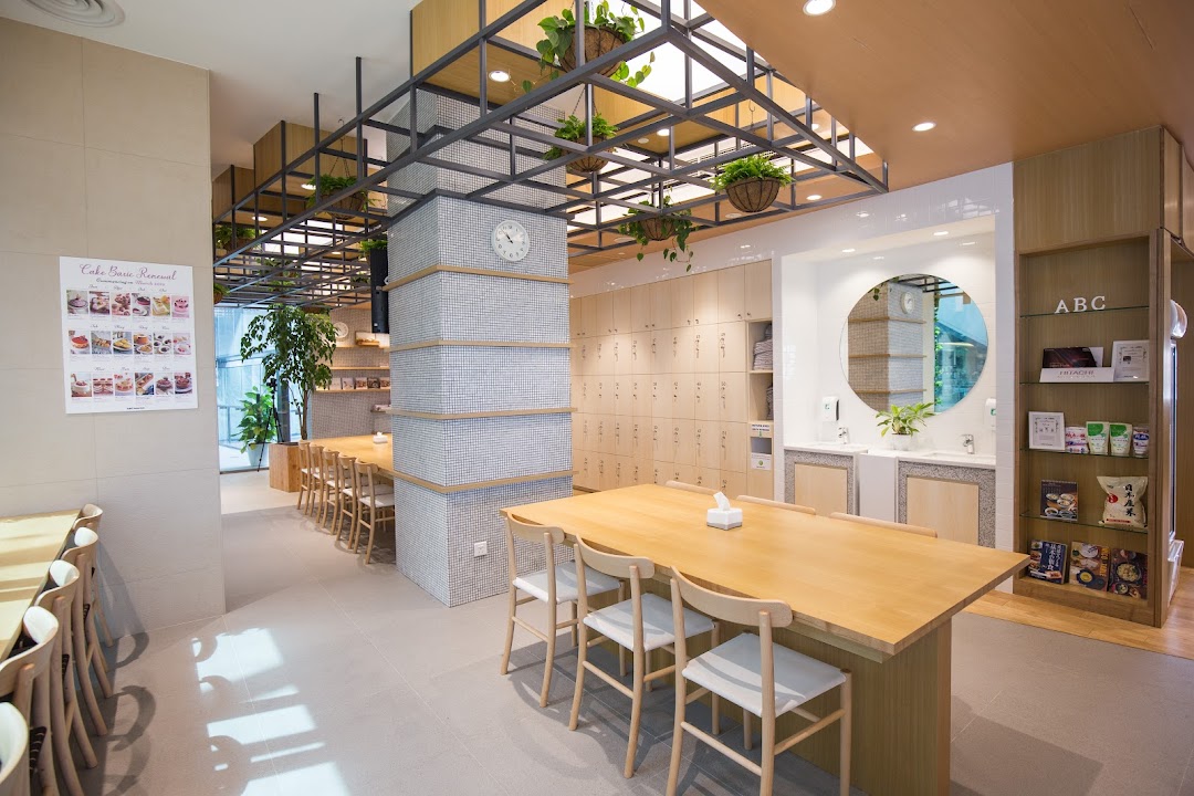Bright, modern interior of ABC Cooking Studio with long wooden tables, lockers, and a display.