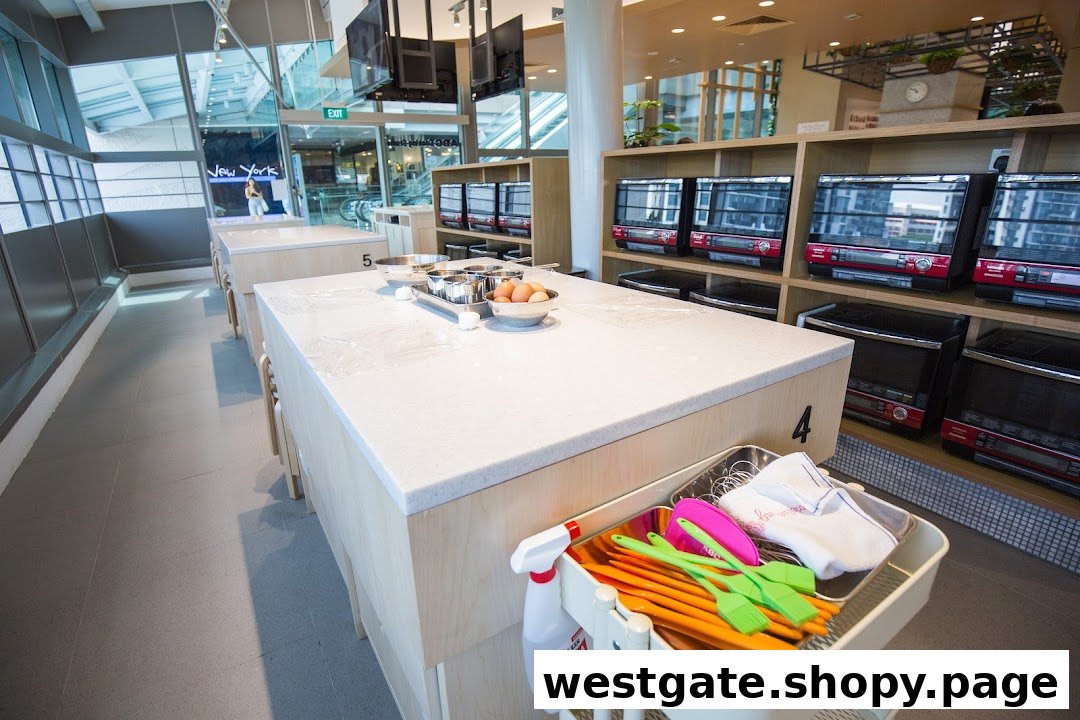 A bright, modern cooking studio interior with workstations, baking ingredients, and ovens.