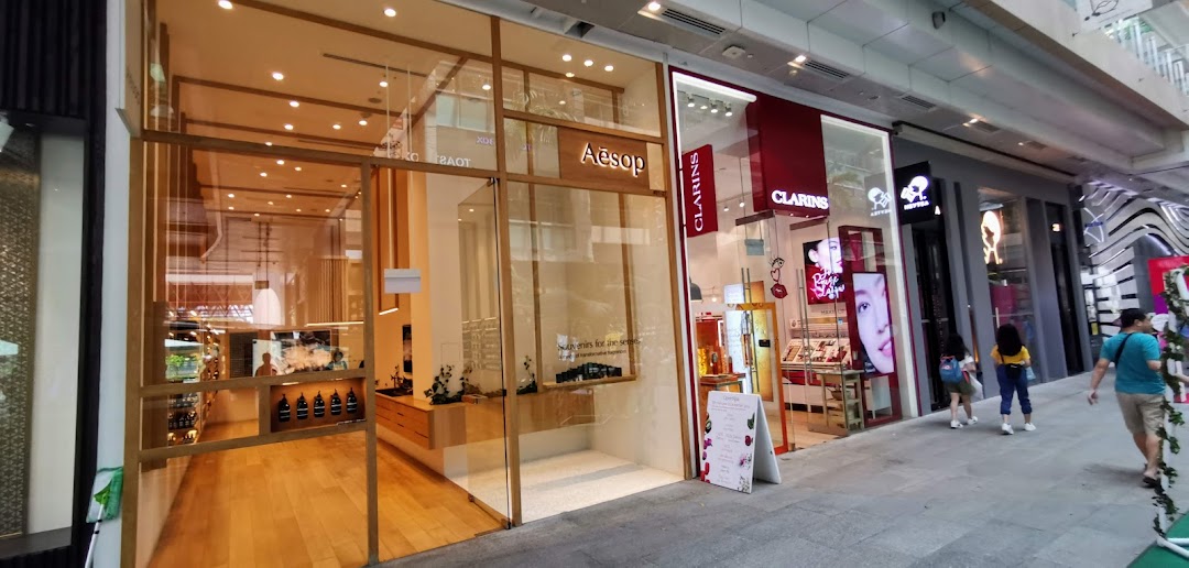 The elegant glass and wood exterior of an Aesop store, showcasing its minimalist design and products.