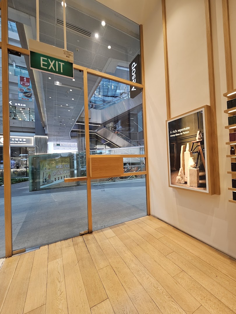 Aesop store entrance with glass doors opening to a bright shopping mall interior.