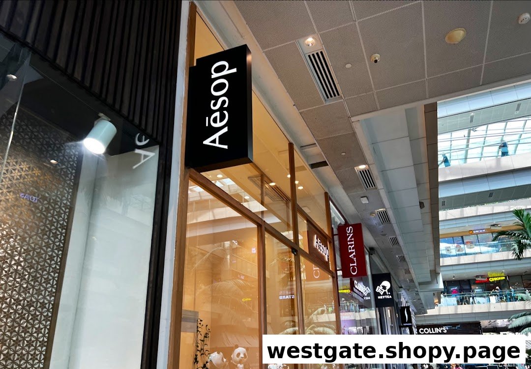 The exterior of an Aesop store with its prominent black and white sign in a modern shopping mall.