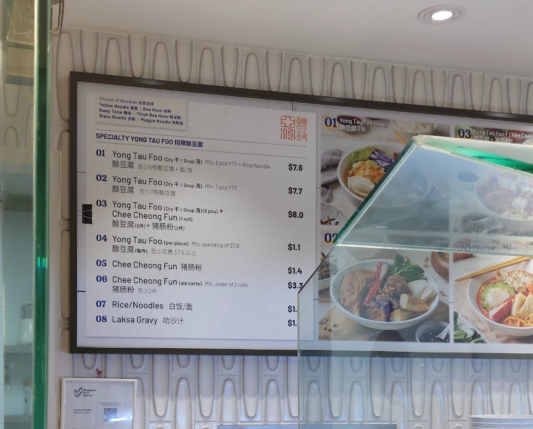 A menu board displaying Yong Tau Foo dishes with prices and noodle choices.