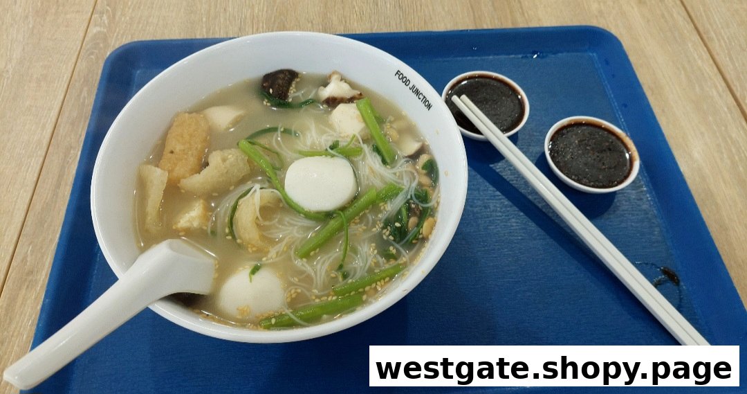 A delicious bowl of Yong Tau Foo with noodles, vegetables, and fishballs, served with dipping sauces.