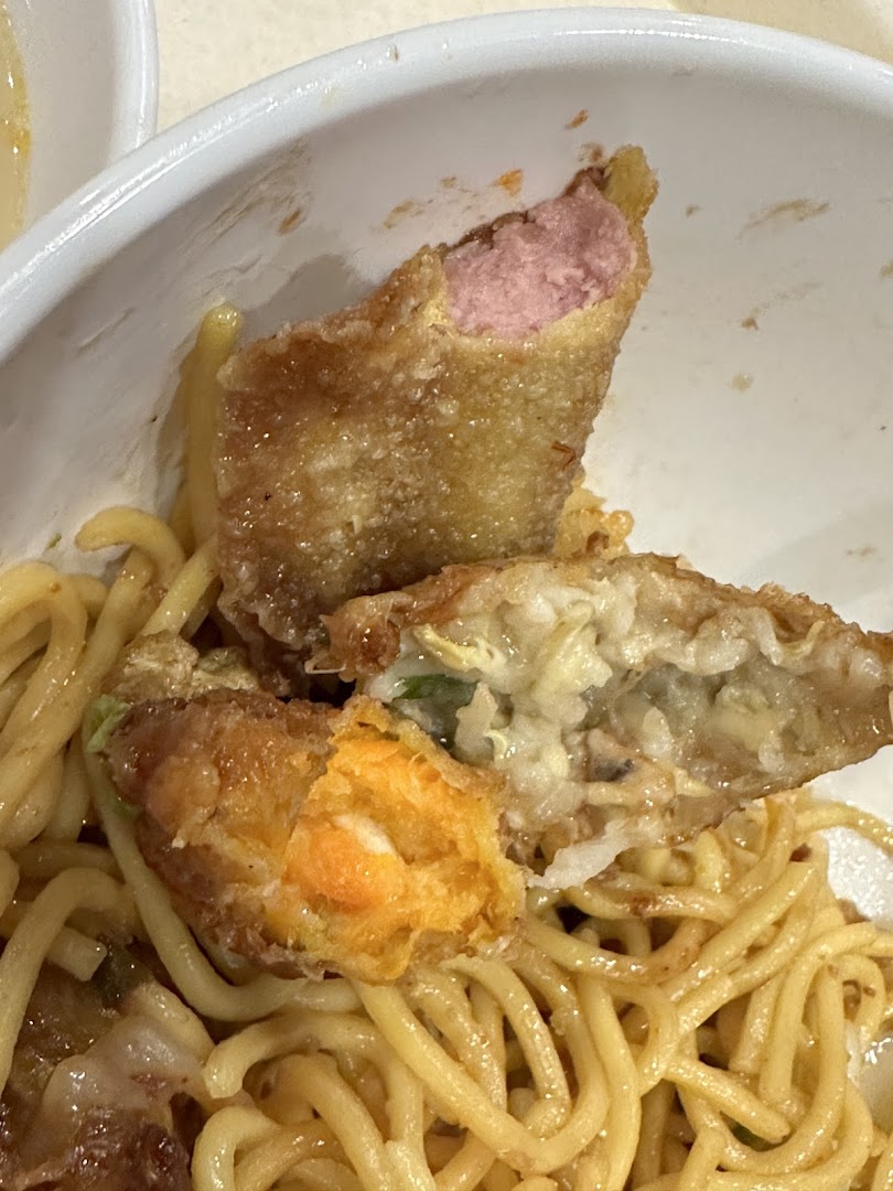 Close-up of Yong Tau Foo with noodles, featuring various fried pieces with different fillings.