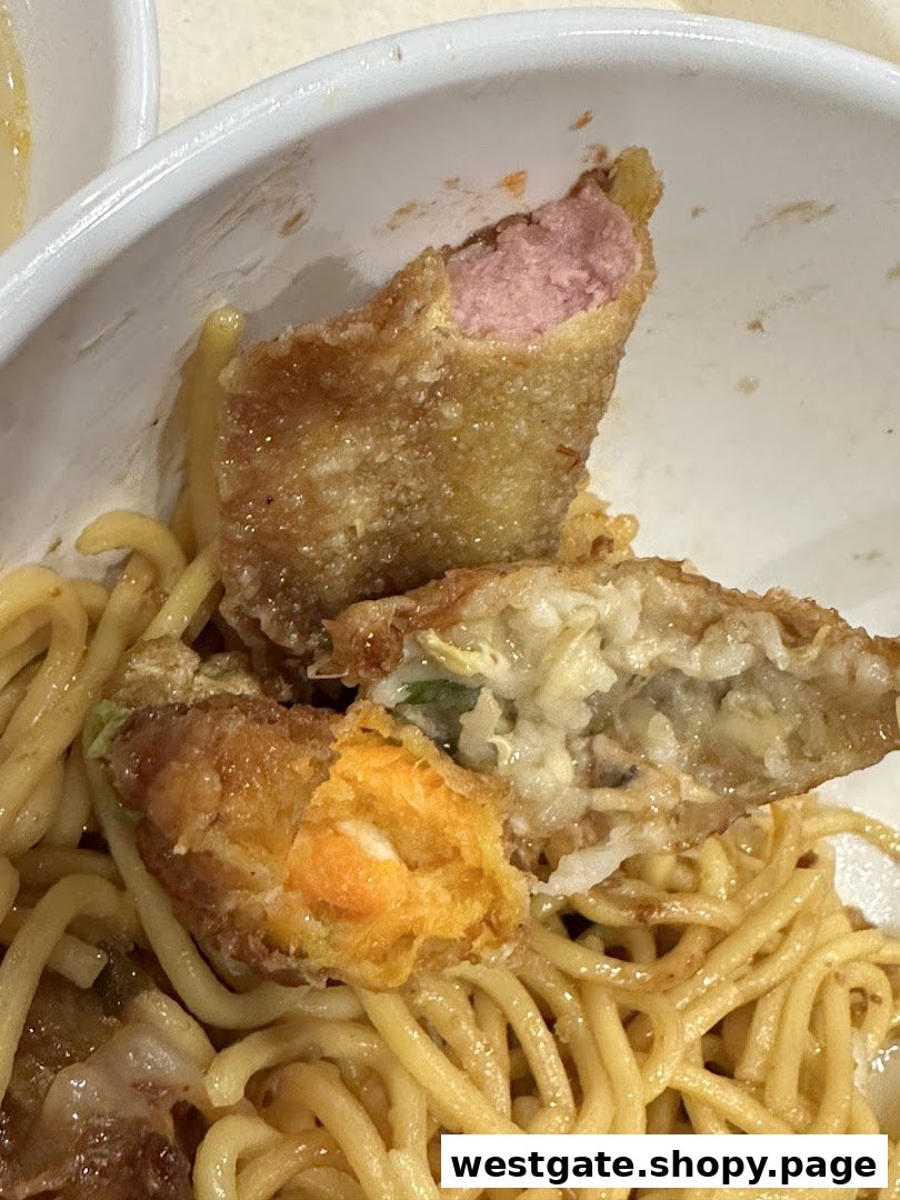 Close-up of Yong Tau Foo with noodles, featuring various fried pieces with different fillings.