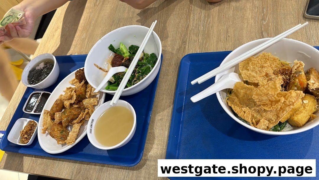 Two trays of delicious Yong Tau Foo dishes with various ingredients and sides on a wooden table.