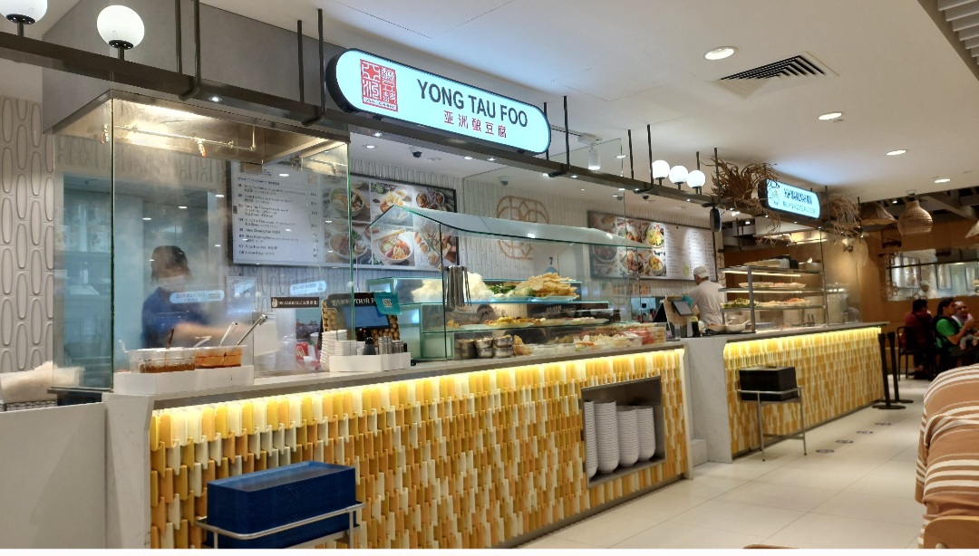 A vibrant counter of Ah Chew Yong Tau Foo, showcasing fresh ingredients and a clear menu board.