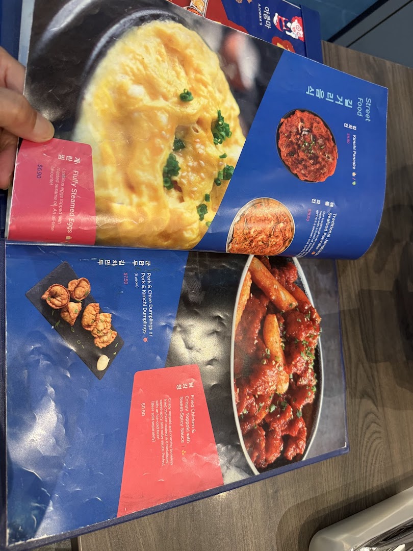 A close-up view of a Korean restaurant menu displaying various dishes with prices and descriptions.