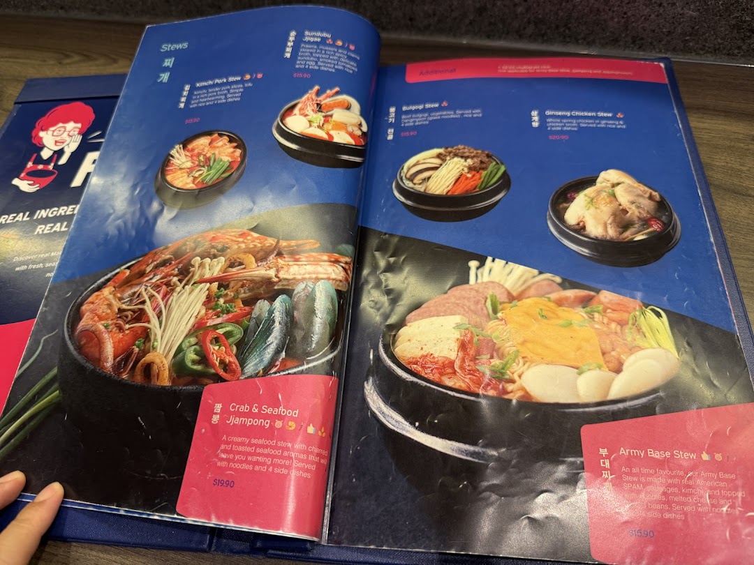 An open menu displaying various hearty Korean stews with vibrant photos and detailed descriptions.