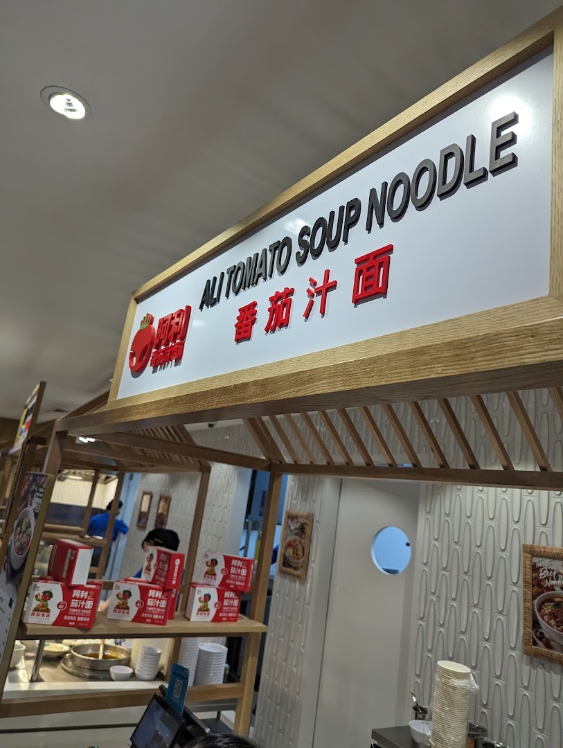 An interior view of Ali Tomato Soup Noodle, highlighting its prominent signage and serving area.
