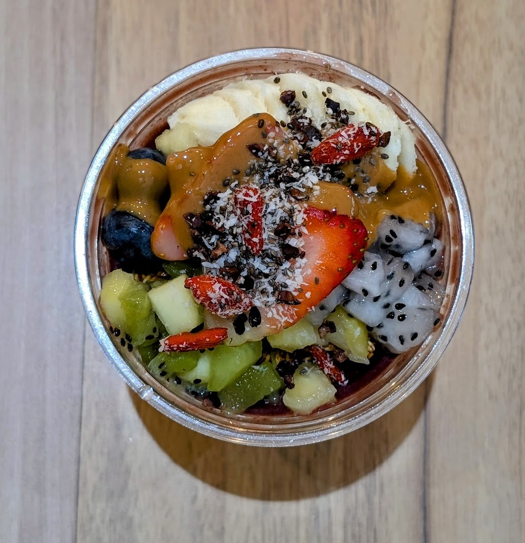 A vibrant açaí bowl topped with fresh fruits, nuts, and drizzles.