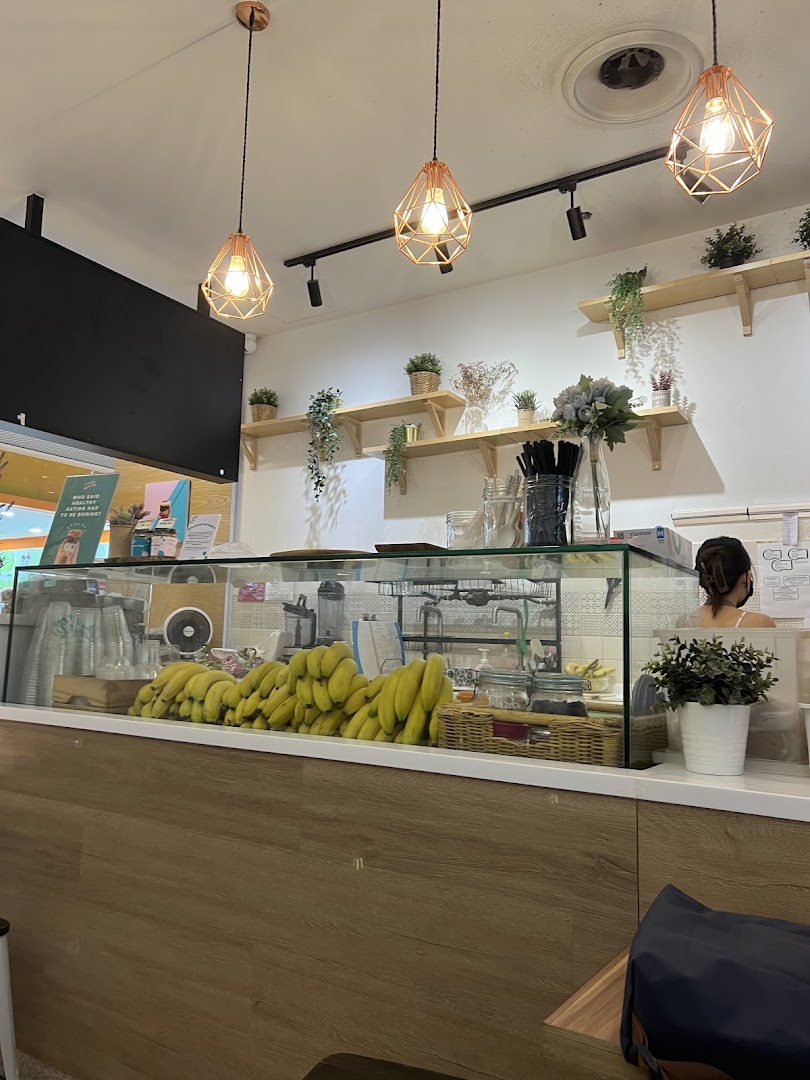 Interior view of An Açaí Affair, showing the counter with fresh bananas and a staff member.