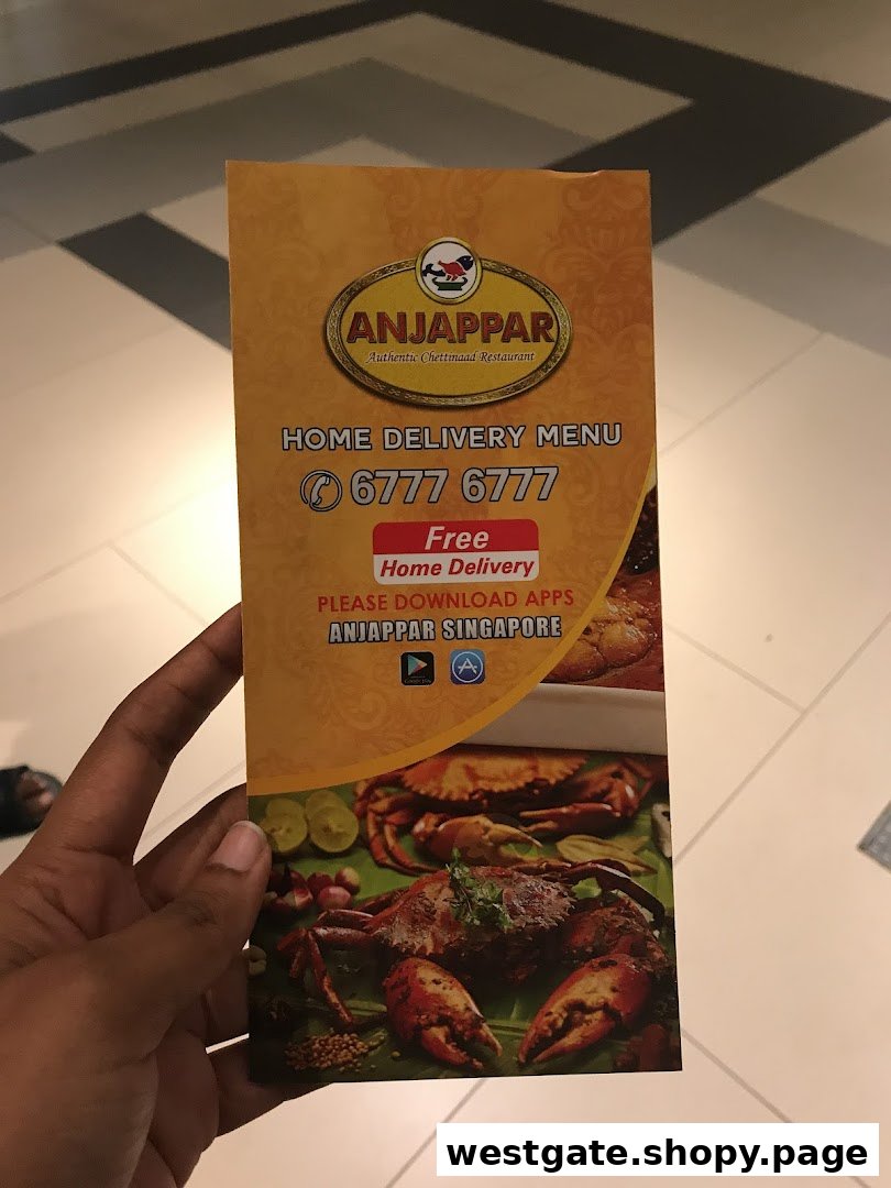 A hand holds an Anjappar Chettinaad Restaurant home delivery menu with contact details.
