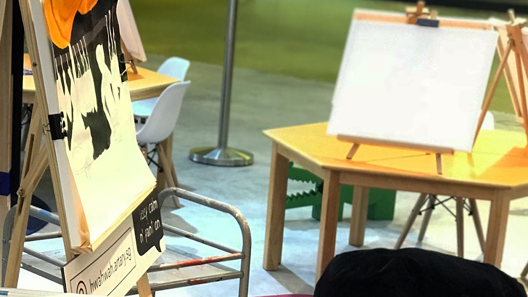 An interior shot of ARTARY Jurong, featuring art easels, tables, and a partially completed painting.