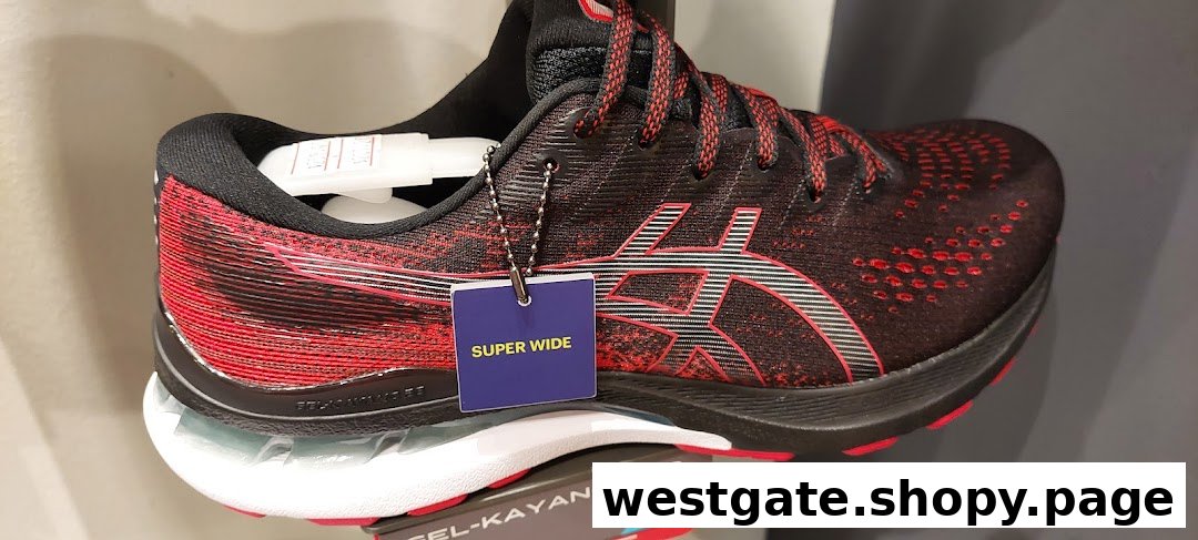 A close-up of a black and red ASICS running shoe with a 'SUPER WIDE' tag.