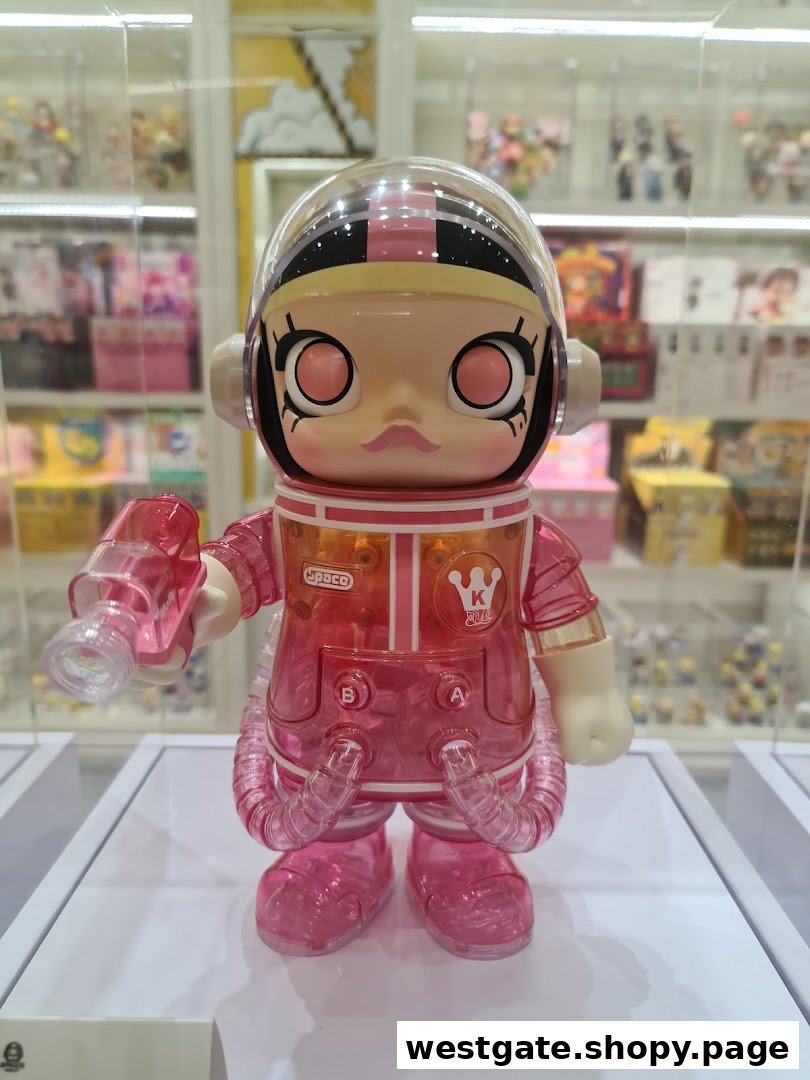 A vibrant pink and clear collectible toy figure, resembling an astronaut, displayed in a retail setting.