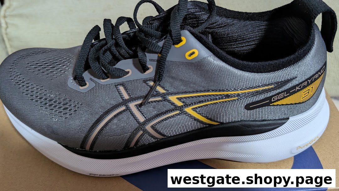 A close-up of a grey ASICS GEL-KAYANO 31 running shoe with yellow accents.