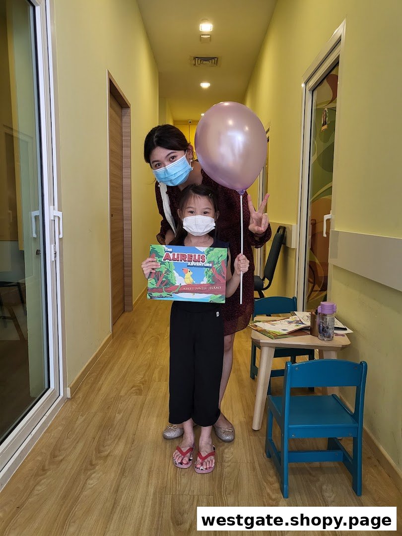 An adult and child, both masked, in a bright hallway, with the child holding an 'Aureus Adventure' book.