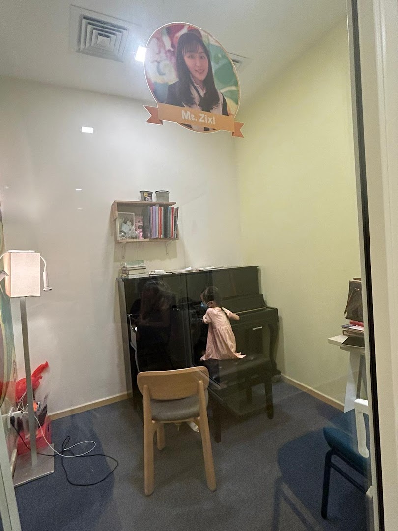 An interior view of a music lesson room at Aureus Academy, featuring a piano and a student.