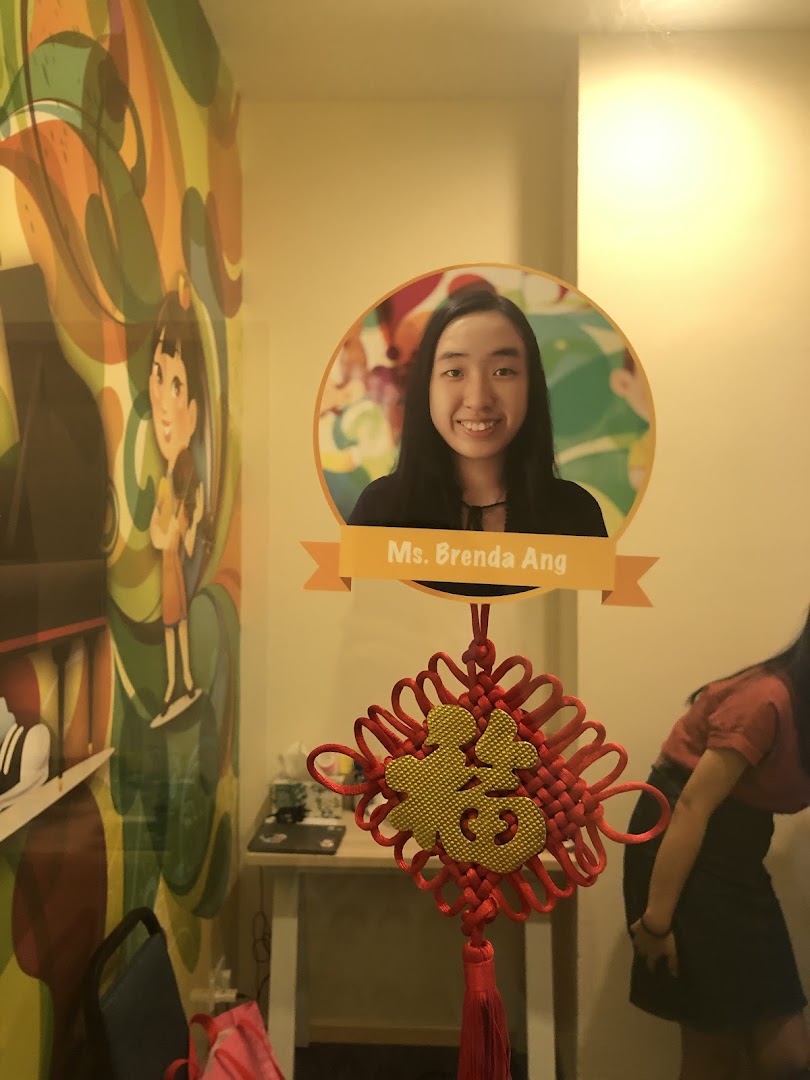 Interior shot of Aureus Academy featuring a colorful mural, Ms. Brenda Ang's photo, and a Chinese knot.