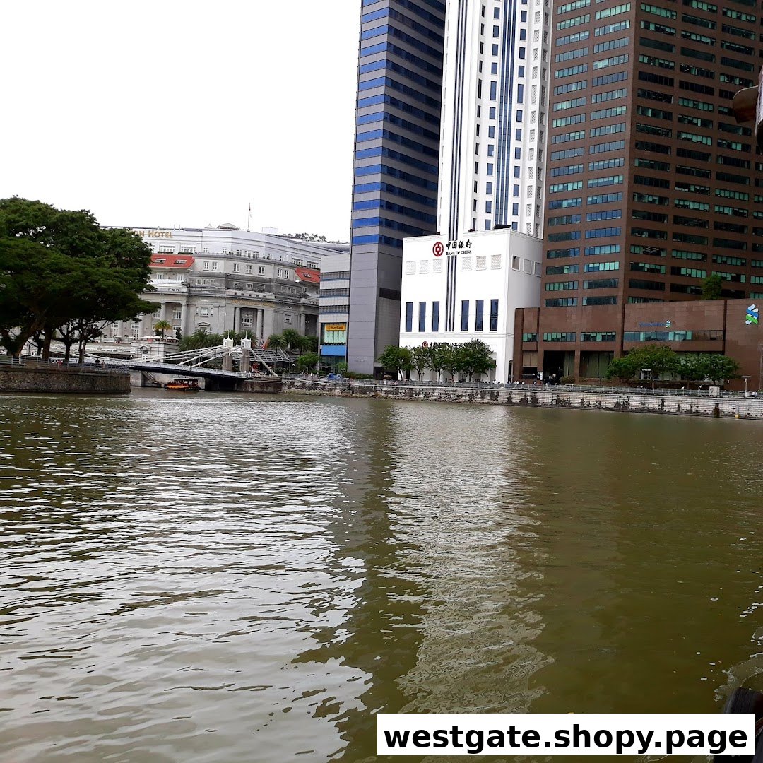 The Bank of China building stands prominently by the river, surrounded by other modern architecture and a bridge.