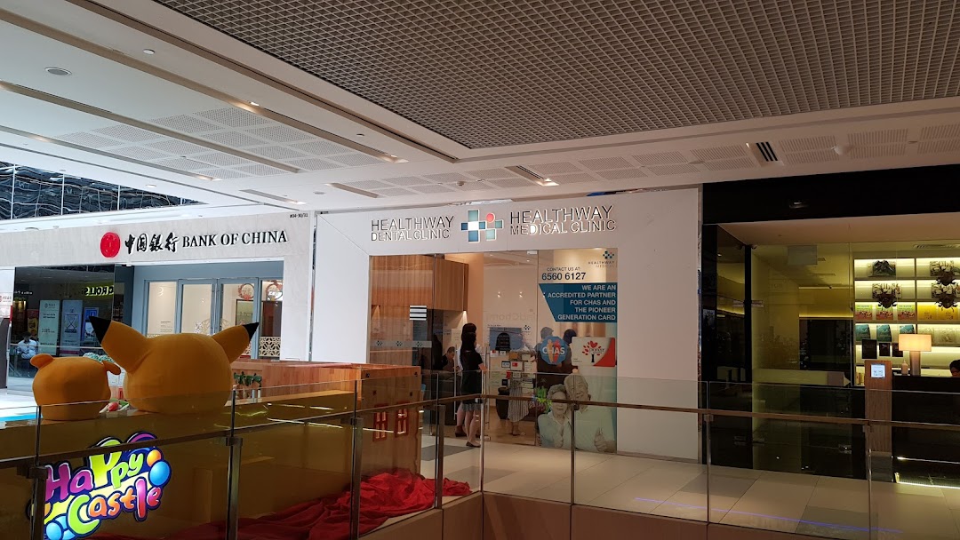 The exterior of Bank of China and Healthway clinics within a bustling shopping mall environment.
