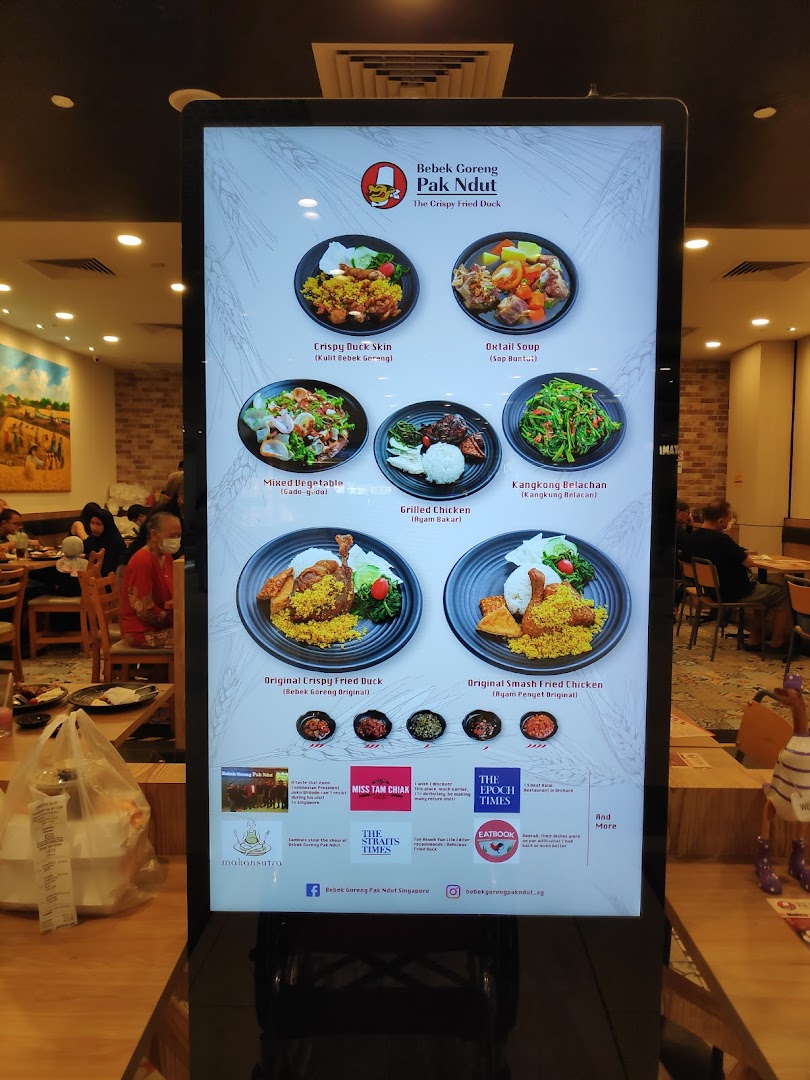A digital menu board displaying various Indonesian dishes and restaurant information.