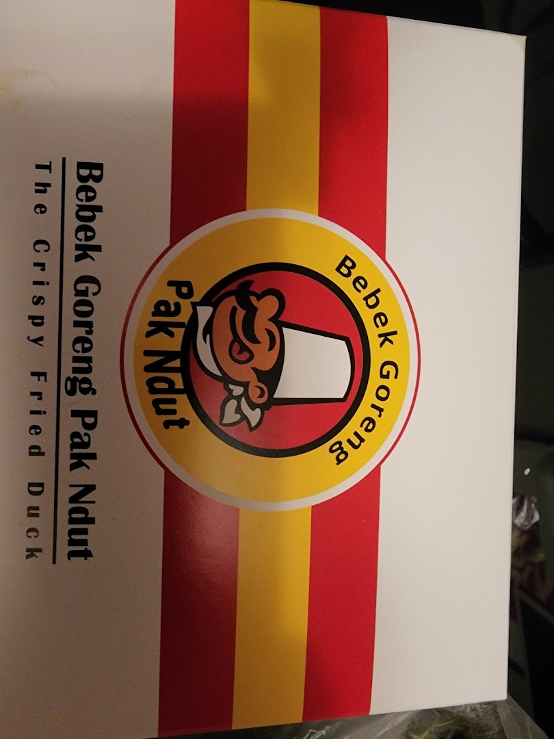 Close-up of Bebek Goreng Pak Ndut's branded packaging, featuring their logo and 'The Crispy Fried Duck' tagline.
