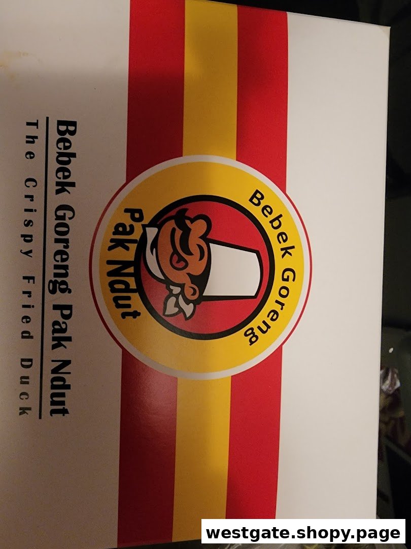 Close-up of Bebek Goreng Pak Ndut's branded packaging, featuring their logo and 'The Crispy Fried Duck' tagline.