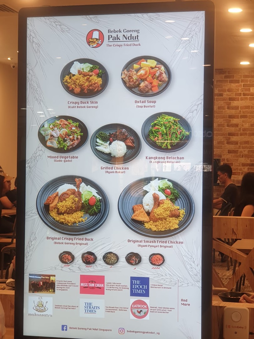 A digital menu board displaying various Indonesian dishes from Bebek Goreng Pak Ndut.