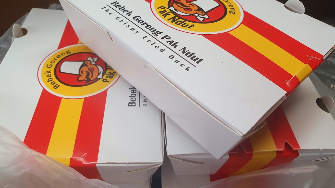 Close-up of multiple takeaway boxes featuring the logo of Bebek Goreng Pak Ndut.