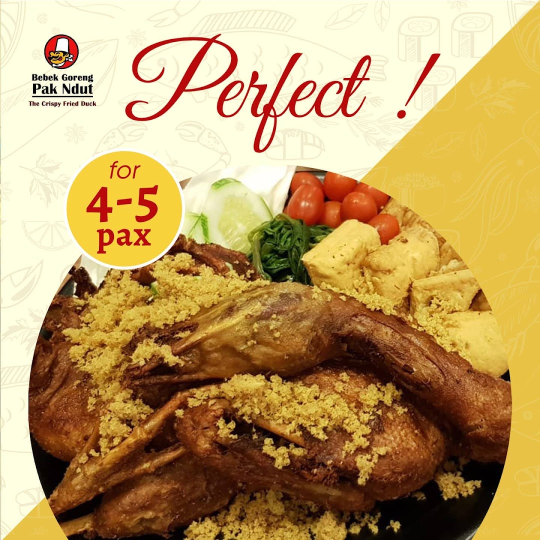 A large platter of crispy fried duck with garnishes, perfect for sharing.