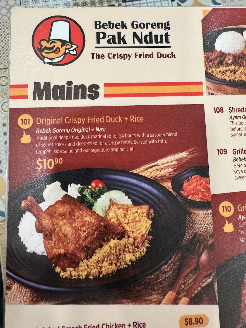 A close-up of Bebek Goreng Pak Ndut's menu, featuring their signature crispy fried duck.