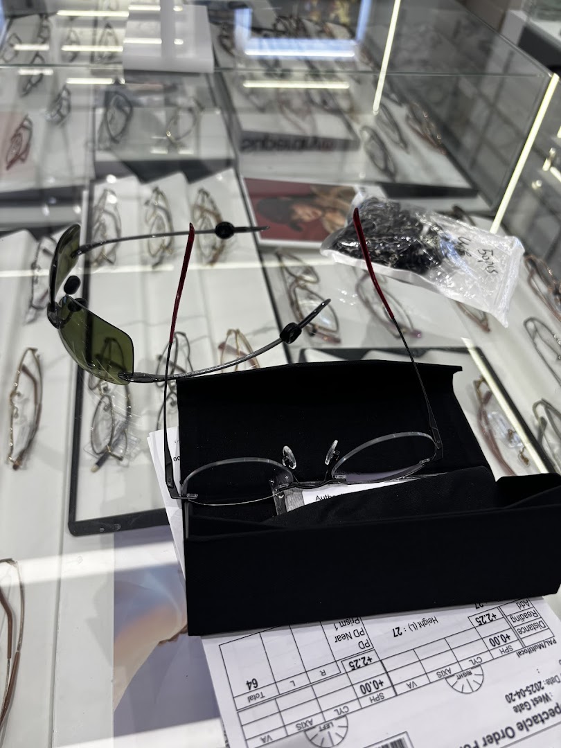 A close-up view of eyeglasses and sunglasses displayed in a modern optical shop, with a spectacle order form visible.