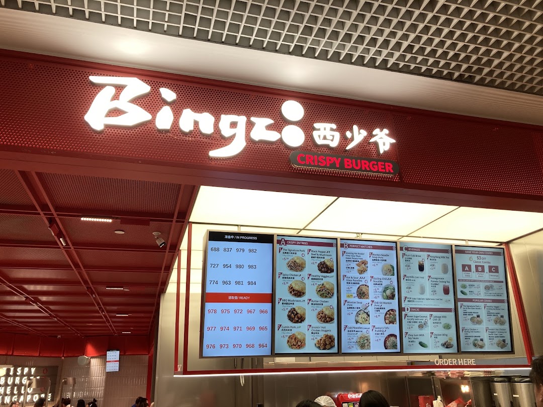 A vibrant red shop front of Bingz Singapore with digital menu boards displaying crispy burgers and sides.