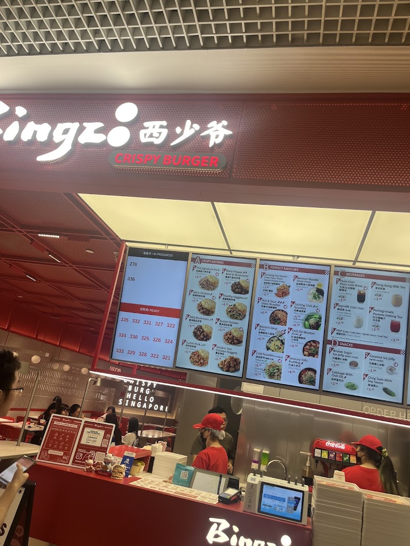 Interior view of Bingz Singapore, showing the ordering counter, staff, and digital menu boards.