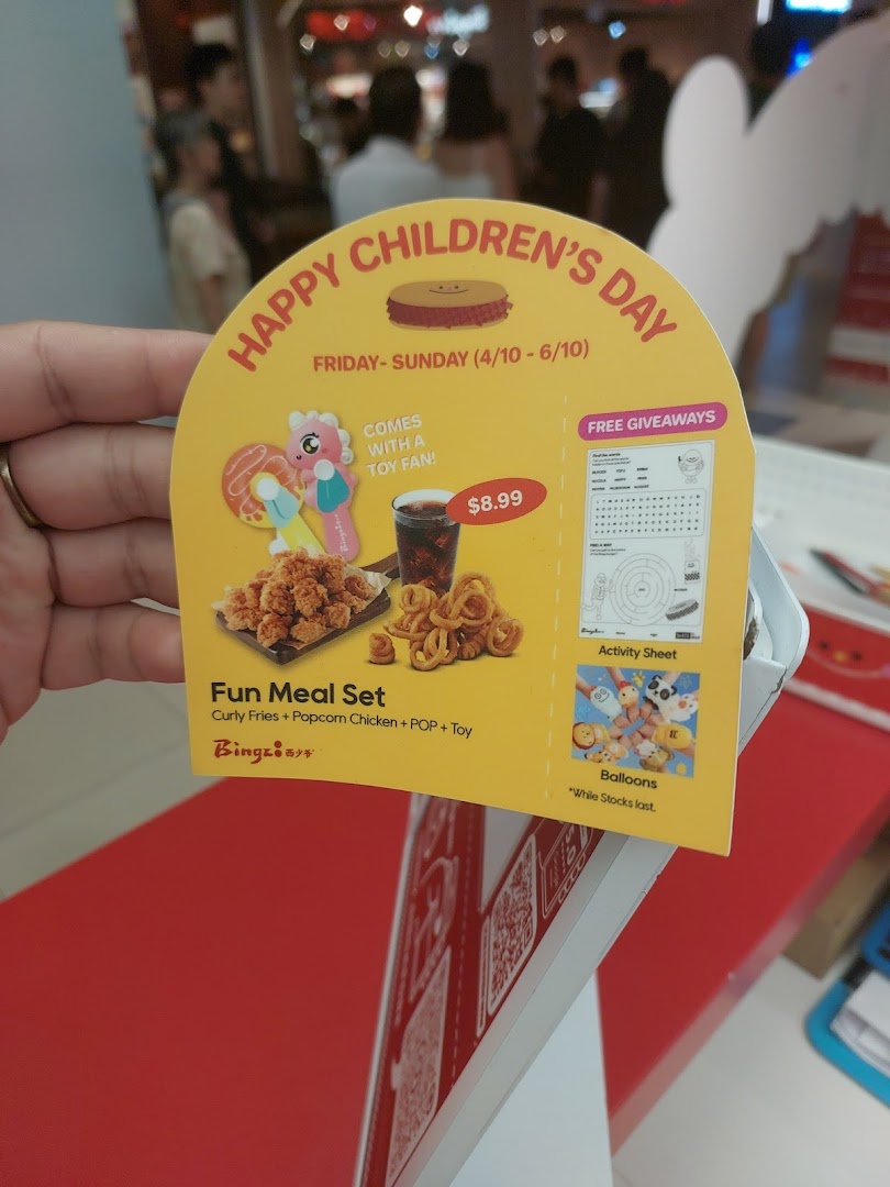 A promotional standee for Bingz's 'Happy Children's Day' Fun Meal Set, featuring food and toys.