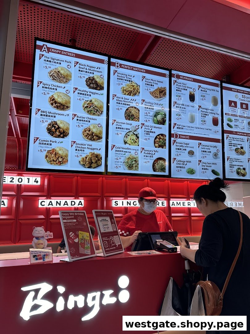A customer orders at the counter of Bingz Singapore, with digital menu boards displaying various food and drink options.