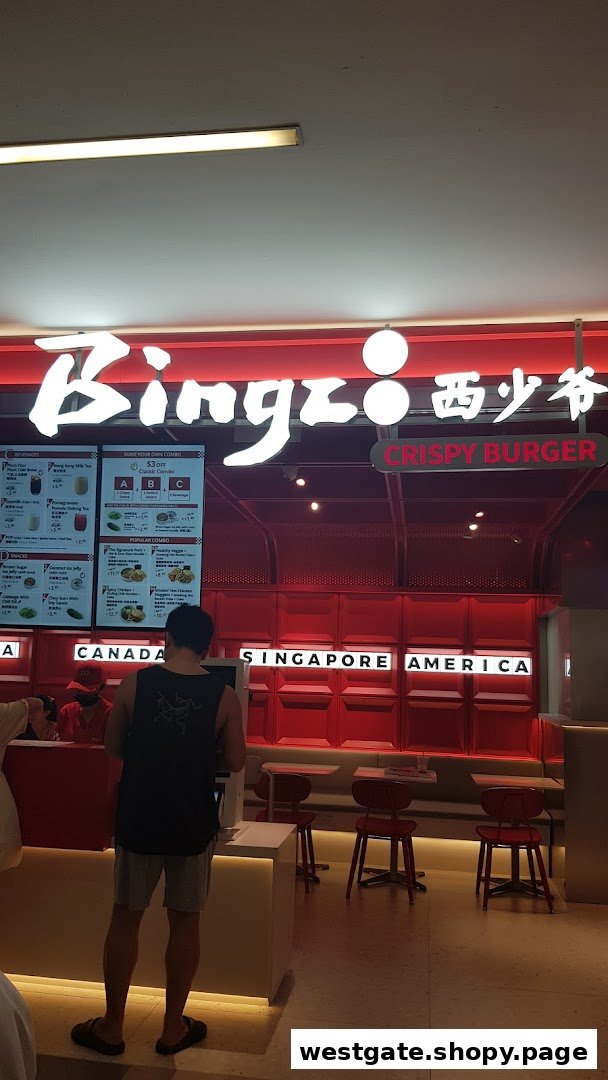 A customer orders at Bingz Singapore, featuring prominent digital menu boards with food and drink options.