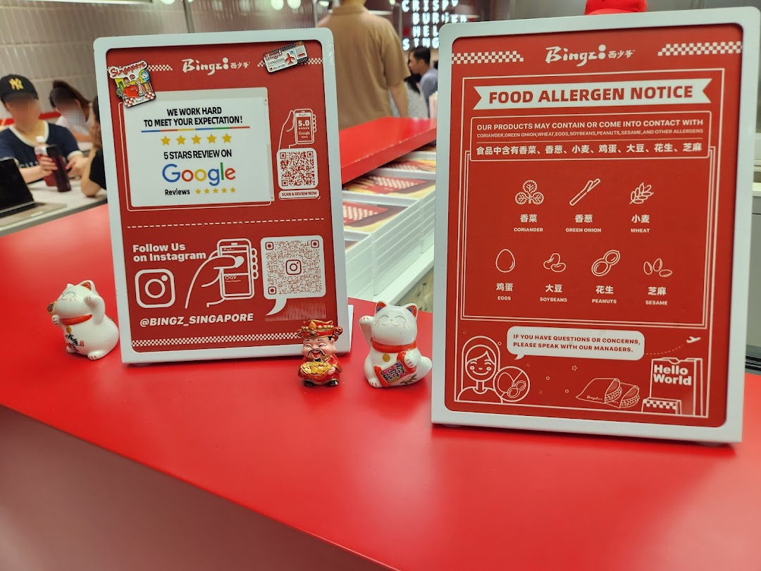Two red display stands on a counter, one for Google reviews/Instagram, the other for food allergen notice.