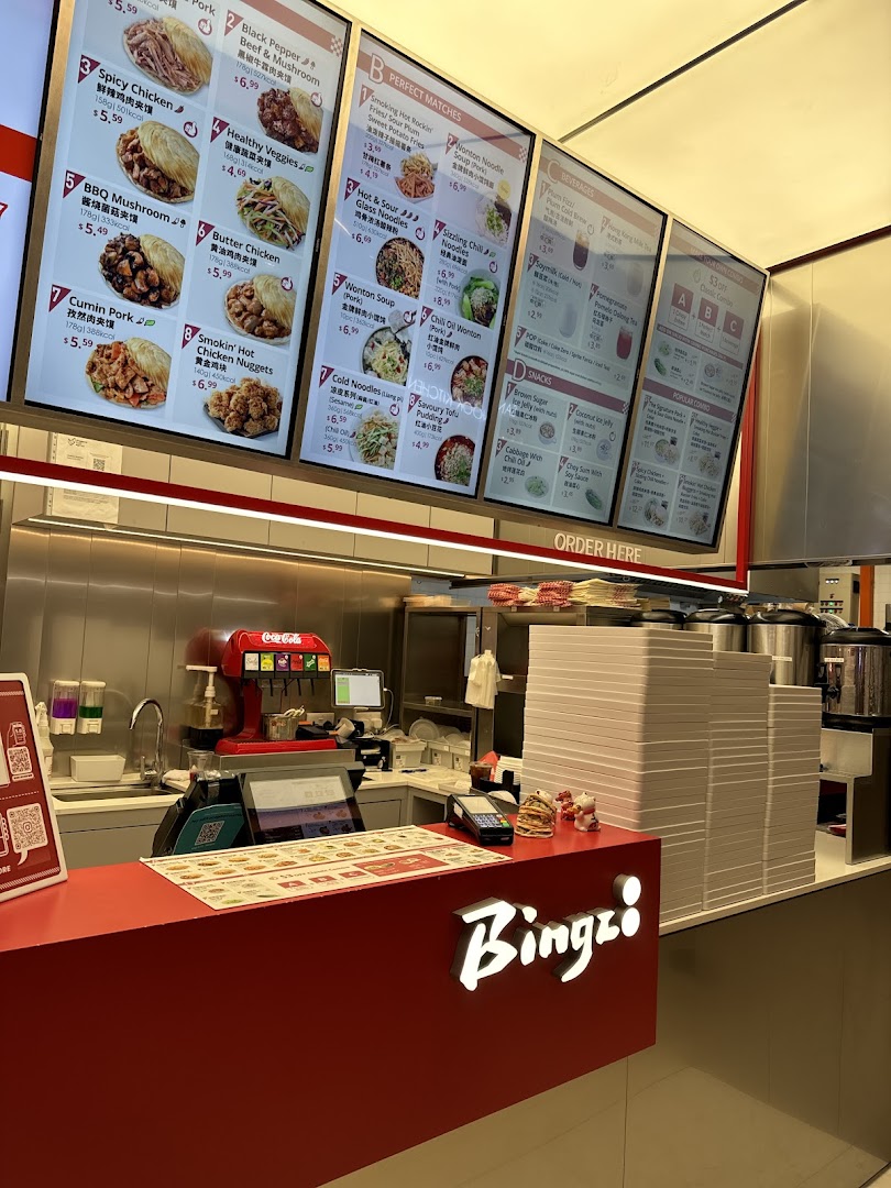 A vibrant counter area of Bingz, showcasing large digital menu boards with various food and drink options.