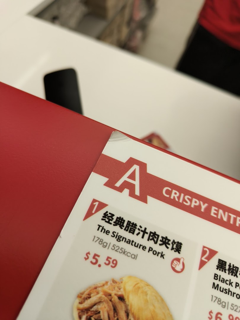 A close-up of Bingz Singapore's menu, featuring 'The Signature Pork' crispy entree with its price and nutritional information.