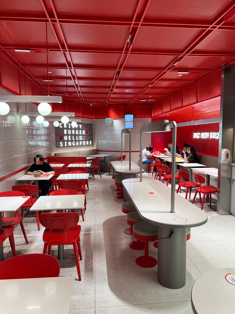 Vibrant red and white interior of Bingz Singapore, featuring various seating arrangements and customers dining.