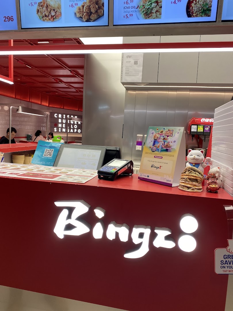 A vibrant red counter with the illuminated 'Bingz' logo, payment terminal, and digital menu screens in the background.